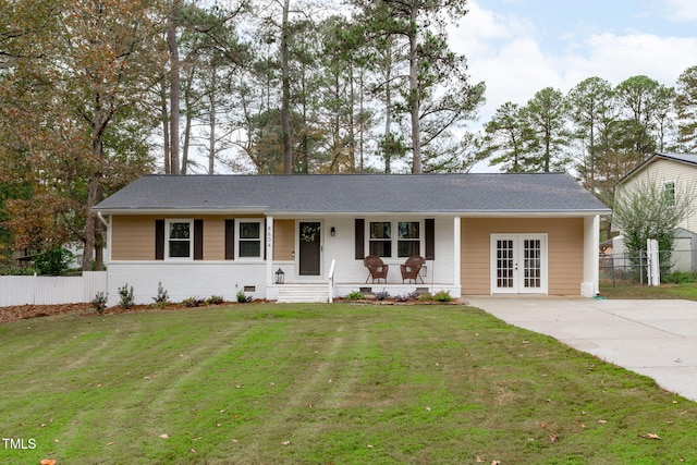 ranch-style house featuring french doors, a front lawn, and covered porch