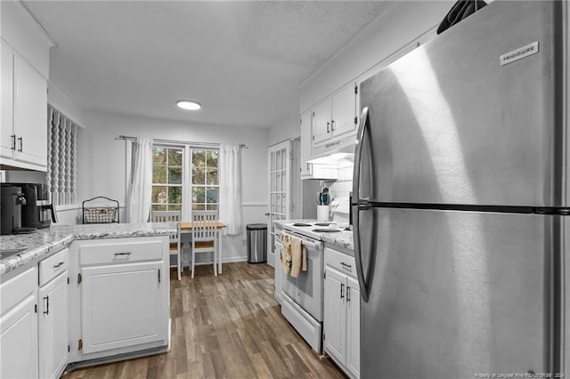 kitchen featuring white cabinets, electric stove, dark hardwood / wood-style floors, stainless steel fridge, and light stone counters