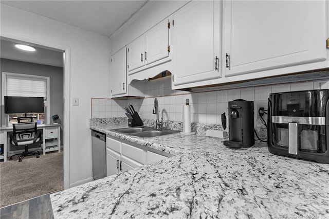 kitchen featuring carpet floors, sink, stainless steel dishwasher, decorative backsplash, and white cabinetry