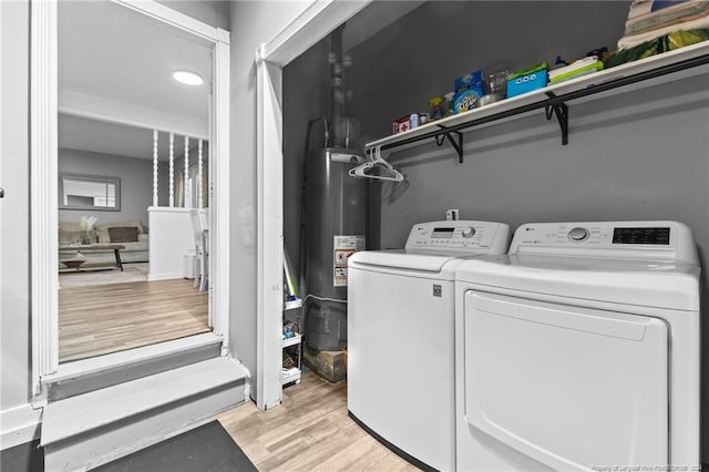 washroom with washer and dryer, gas water heater, and light hardwood / wood-style floors