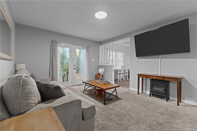 living room featuring carpet floors and a wood stove