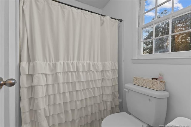 bathroom with curtained shower and toilet