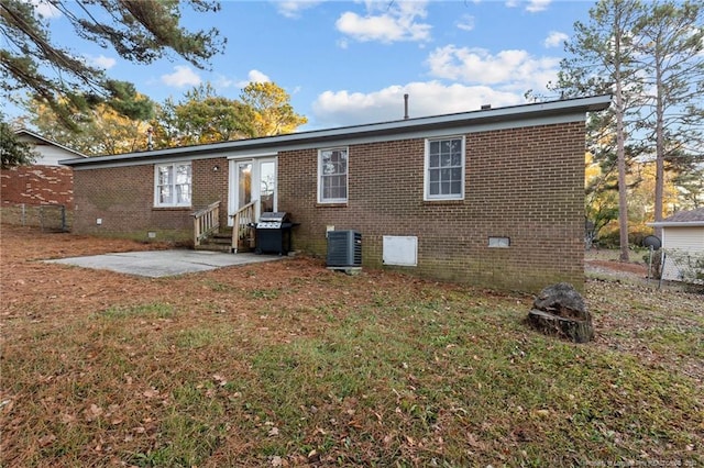 rear view of property featuring a yard, a patio, and central AC unit