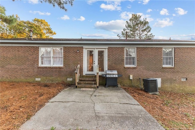 view of front of property with central air condition unit, a patio, and french doors