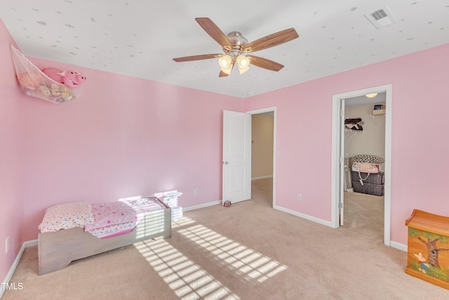 carpeted bedroom with a spacious closet, a closet, and ceiling fan