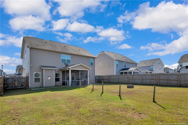 rear view of property featuring a sunroom and a yard