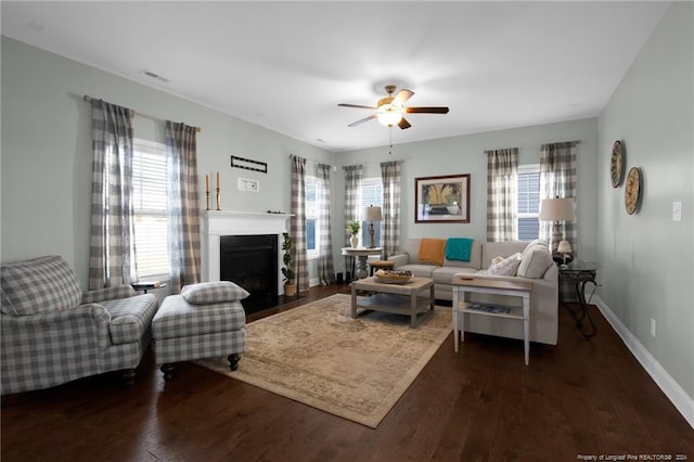 living room featuring a wealth of natural light, dark wood-type flooring, and ceiling fan