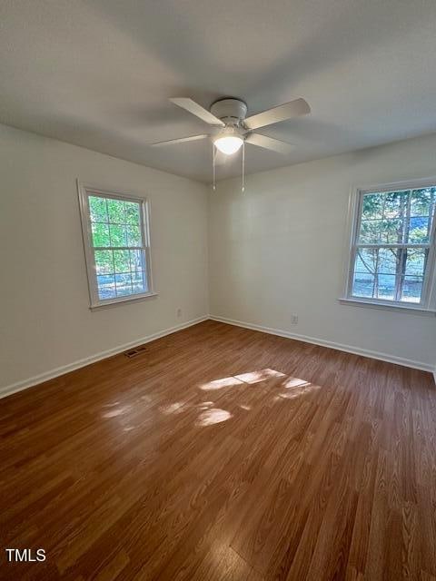 empty room featuring ceiling fan and dark hardwood / wood-style flooring