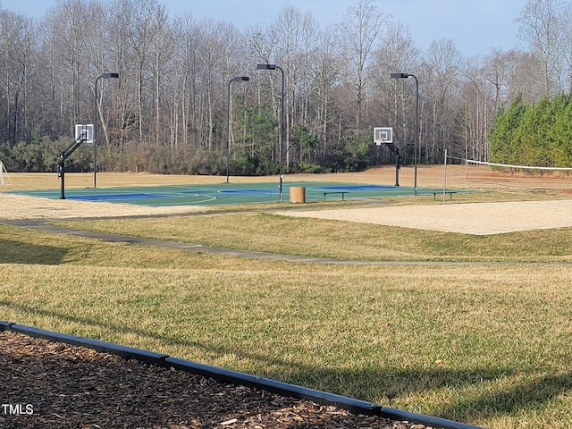 view of sport court featuring a lawn and volleyball court