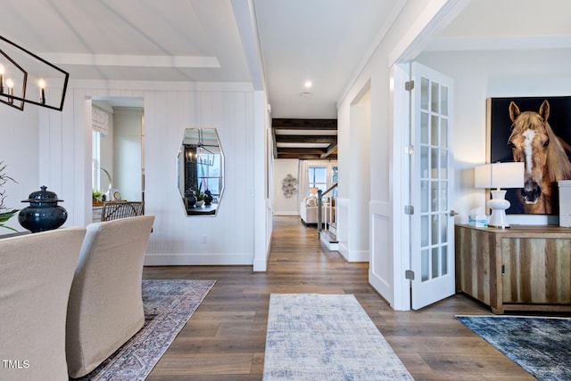 entryway with dark wood-type flooring, a chandelier, and beam ceiling