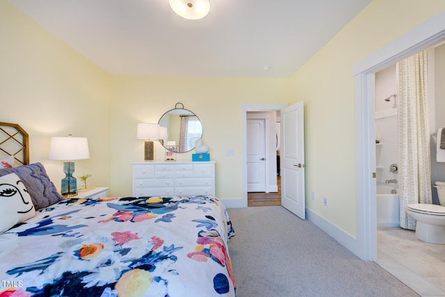 bedroom with light colored carpet and ensuite bathroom