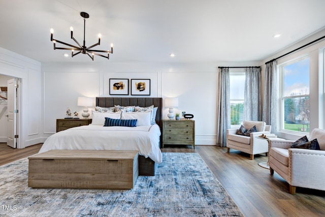 bedroom with wood-type flooring and a chandelier