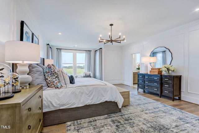 bedroom featuring light hardwood / wood-style floors and a chandelier