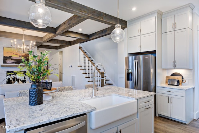 kitchen with white cabinetry, sink, decorative light fixtures, and appliances with stainless steel finishes