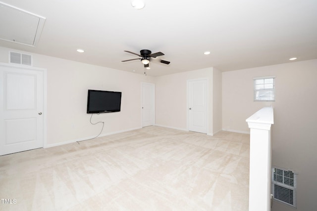 basement featuring ceiling fan and light colored carpet