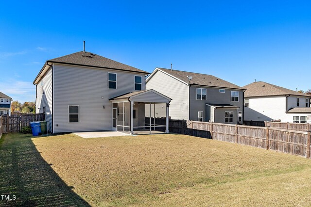 back of property featuring a patio area, a sunroom, and a lawn