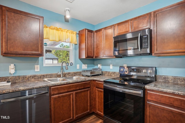 kitchen with stainless steel appliances, dark hardwood / wood-style floors, and sink