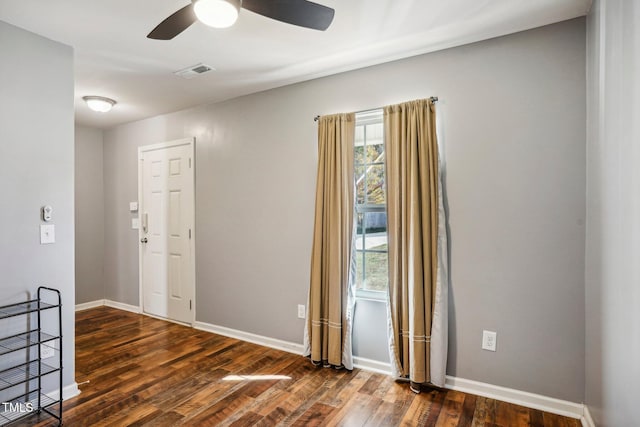 unfurnished room with ceiling fan and dark wood-type flooring