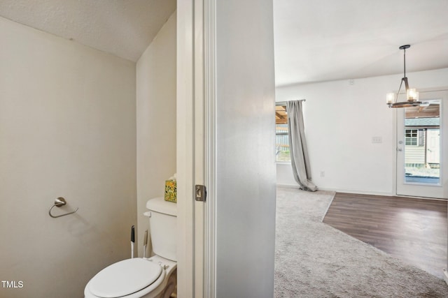 bathroom featuring vaulted ceiling, toilet, a notable chandelier, and hardwood / wood-style flooring