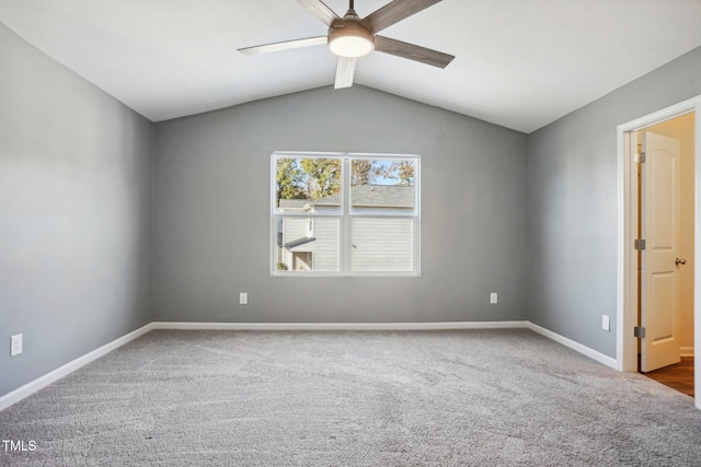 carpeted spare room featuring vaulted ceiling and ceiling fan