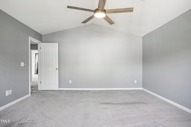 carpeted spare room featuring vaulted ceiling and ceiling fan