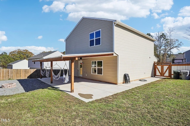 back of house with a patio area, a yard, and a fire pit