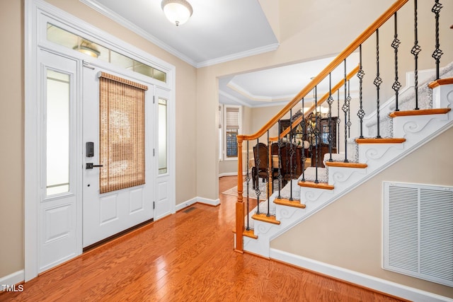 foyer with wood-type flooring and ornamental molding