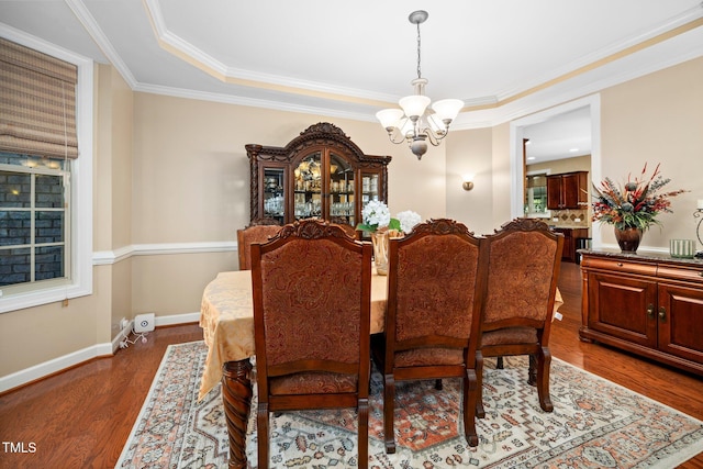 dining room with hardwood / wood-style flooring, ornamental molding, and a chandelier