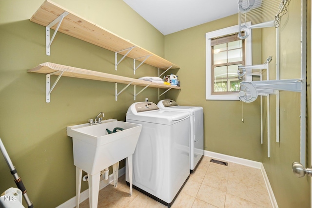 laundry area with washer and dryer and light tile patterned flooring