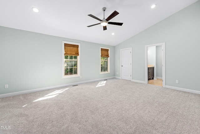 unfurnished bedroom with light carpet, connected bathroom, ceiling fan, and lofted ceiling