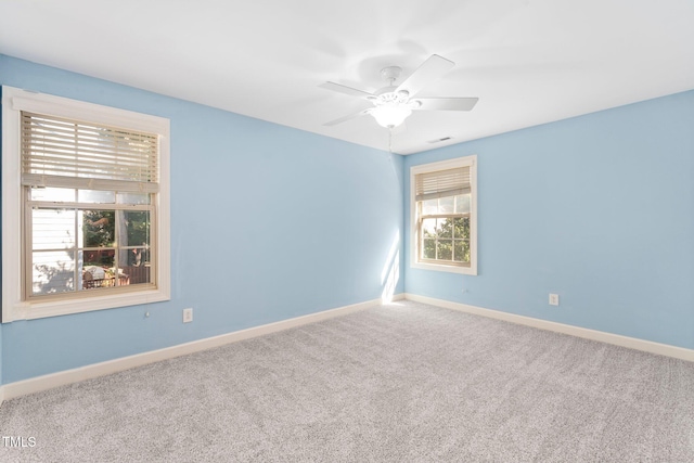 empty room featuring carpet, plenty of natural light, and ceiling fan