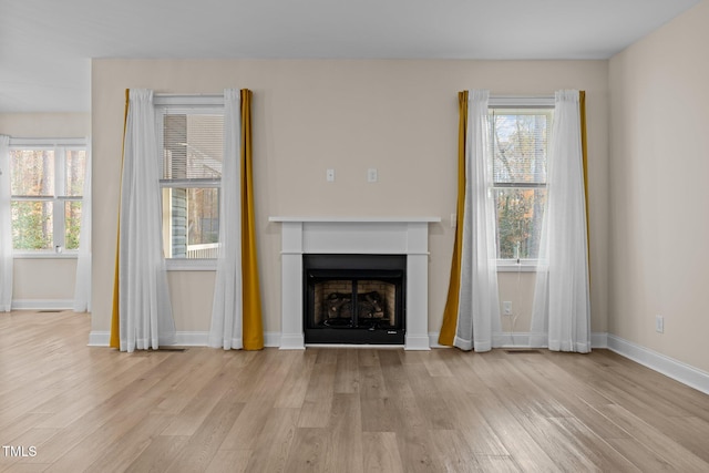 unfurnished living room with light wood-type flooring and plenty of natural light