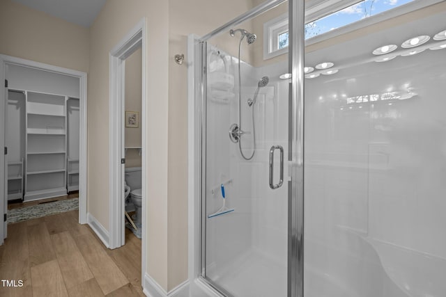 bathroom with an enclosed shower and hardwood / wood-style floors