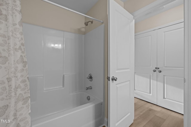 bathroom with hardwood / wood-style flooring and shower / tub combo