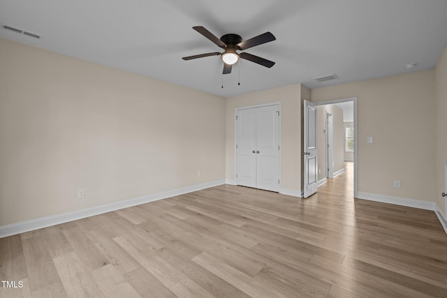 unfurnished bedroom featuring light wood-type flooring, ceiling fan, and a closet