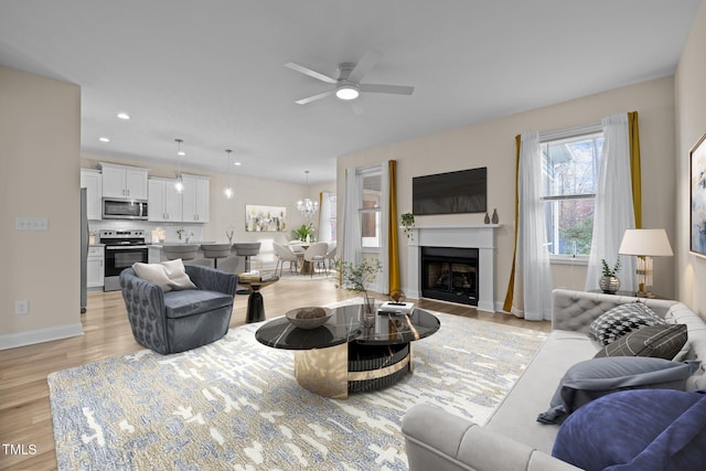 living room featuring light hardwood / wood-style flooring and ceiling fan