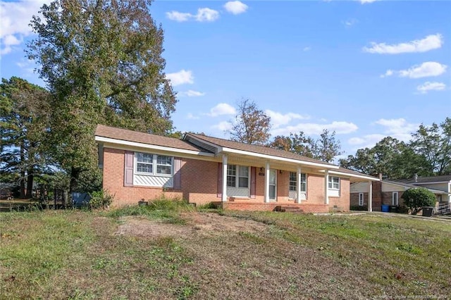 ranch-style home with a front yard and covered porch