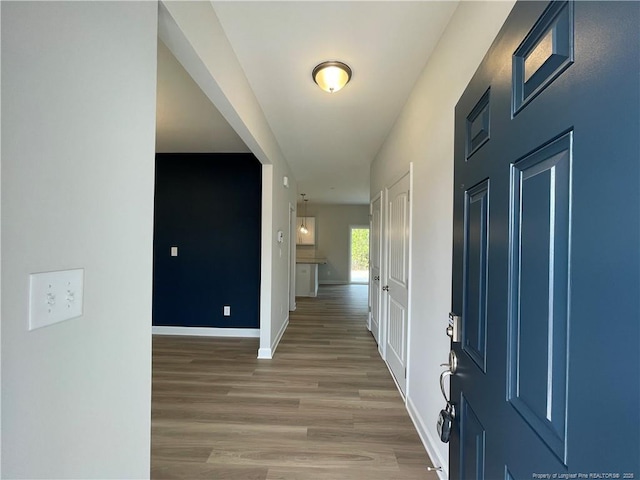 foyer entrance featuring baseboards and light wood finished floors