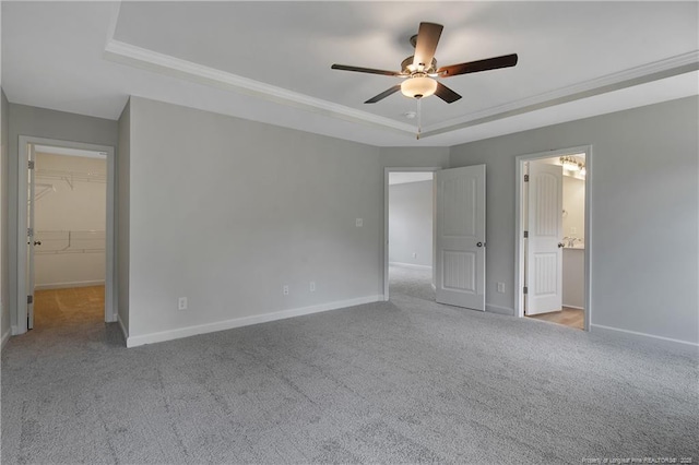 unfurnished bedroom featuring carpet floors, baseboards, and a tray ceiling