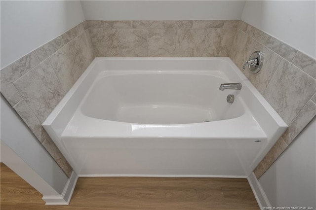 full bathroom with wood finished floors and a garden tub