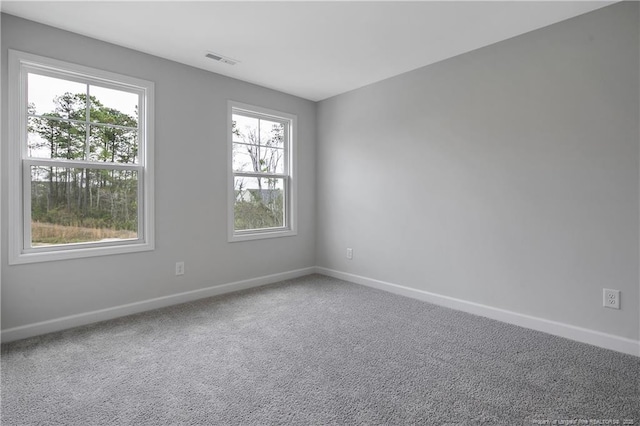 spare room featuring visible vents, carpet, and baseboards