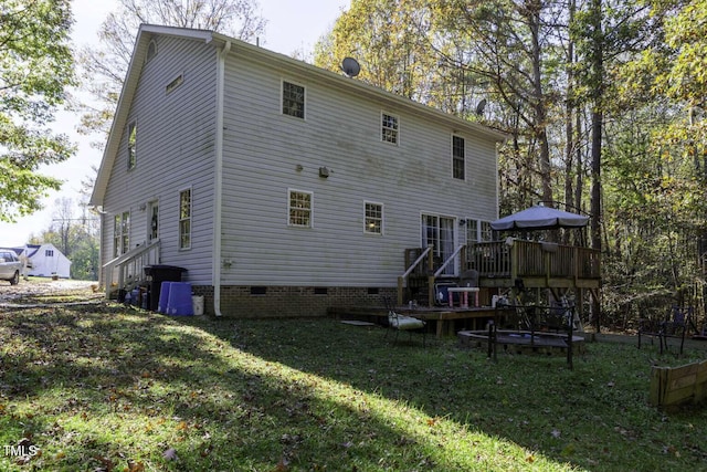 back of house featuring a wooden deck and a yard