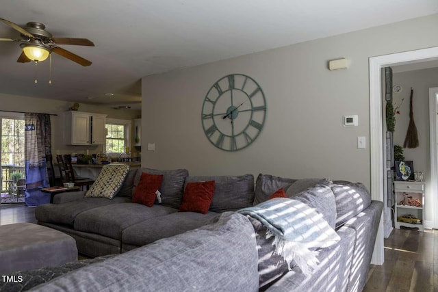 living room with ceiling fan, plenty of natural light, and dark wood-type flooring