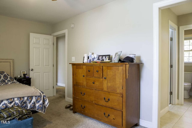 bedroom with light carpet and ensuite bath