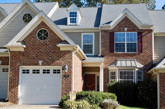 view of front of house featuring brick siding, a garage, driveway, and roof with shingles