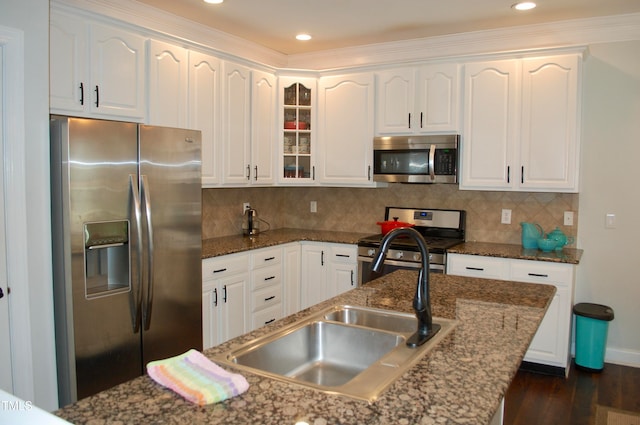 kitchen featuring dark wood finished floors, white cabinets, appliances with stainless steel finishes, and backsplash