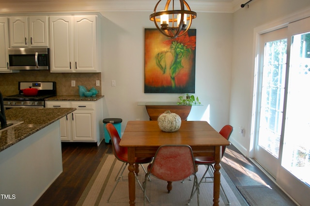 dining area featuring a wealth of natural light, a chandelier, ornamental molding, and dark wood-style flooring