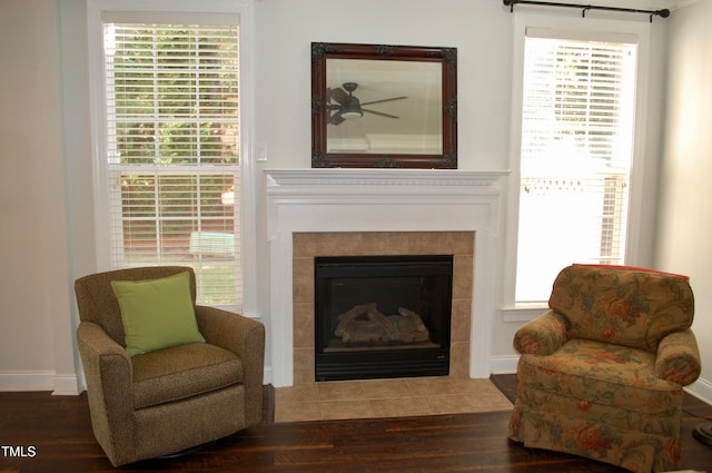 sitting room with baseboards, wood finished floors, and a tile fireplace