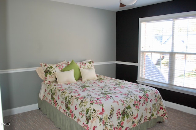 bedroom featuring multiple windows, baseboards, and wood finished floors