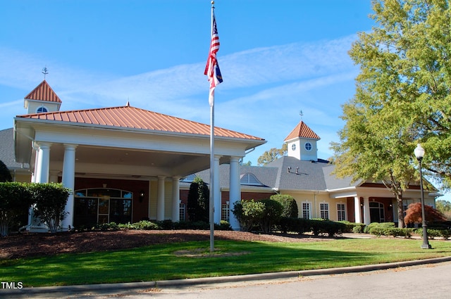 view of front of house featuring metal roof and a front lawn